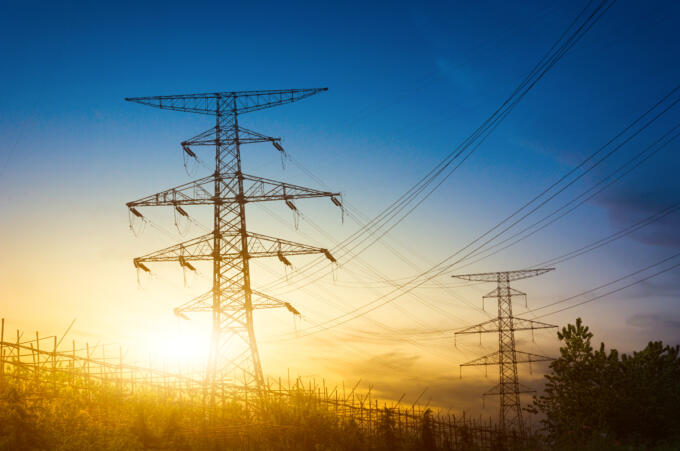 Sun setting silhouette electricity pylons